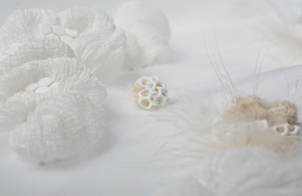 3D Printed Textile Forms Close-up Cluster of white 3D printed forms arranged on fabric